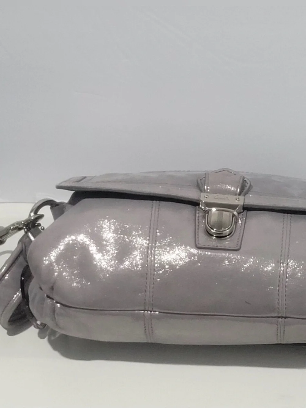 Coach Poppy Layla shimmery leather shoulder bag with a push-lock closure.